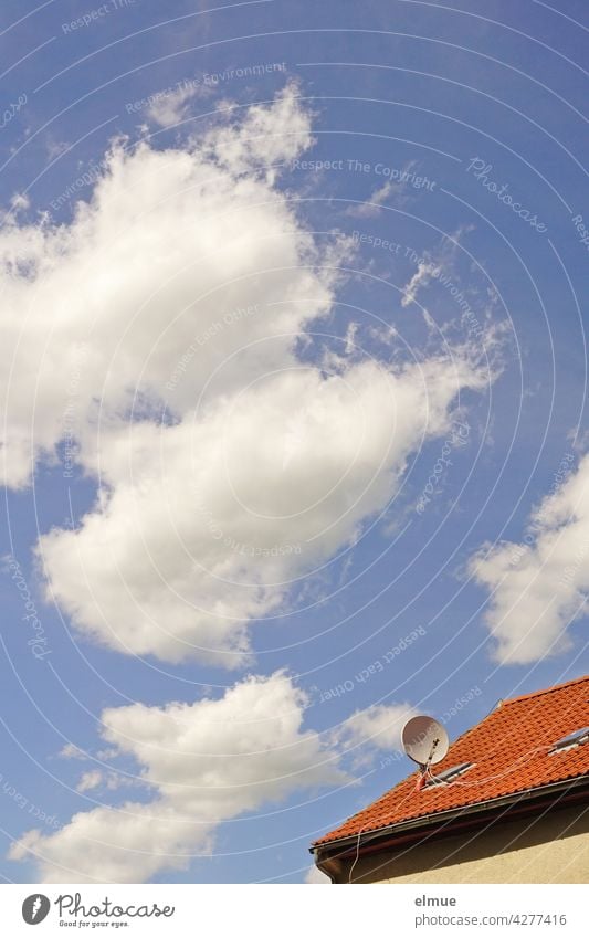 Fair weather clouds in front of a blue sky and a small section of a red tiled roof with a parabolic antenna / satellite dish / football transmission