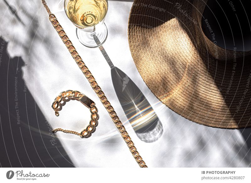 Champagne and gold in summer Champagne glass Gold golden Summer Refreshment beach hat summer hat vacation celebration Occasion Golden necklace Gold bracelet