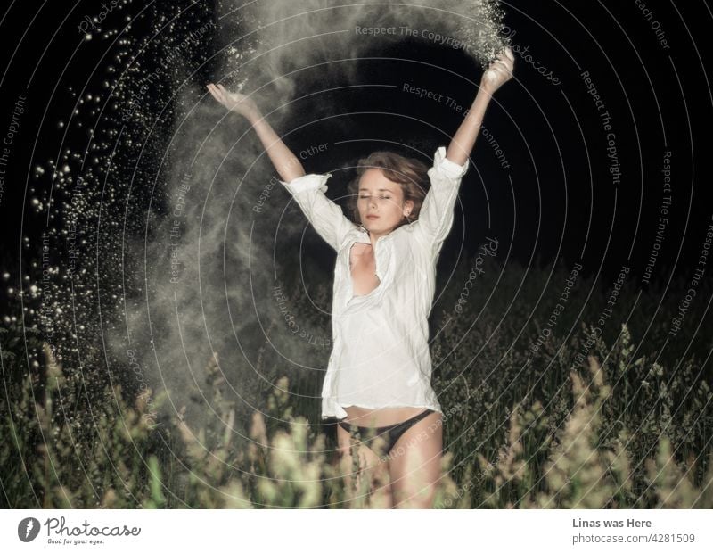 Gorgeous brunette girl is throwing white flour all around herself. It’s a summer night and some weeds are growing in this field. Our model is wearing only black panties and a white t-shirt. Which is a nice outfit for weather and action like this.
