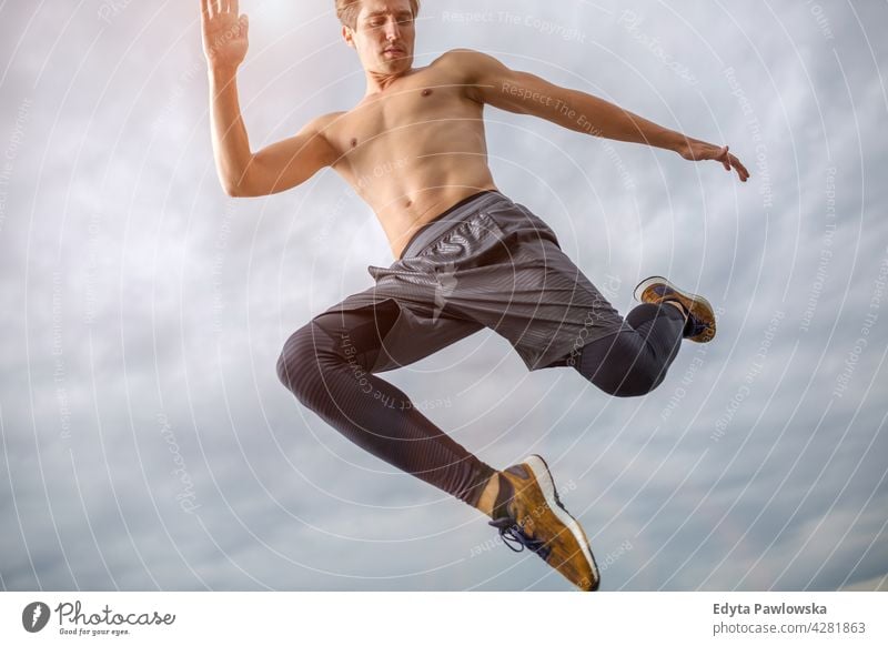 Man jumping against the sky people person guy fashionable serious sexy fit slim body hair style standing one stylish caucasian man boy expression men lifestyle