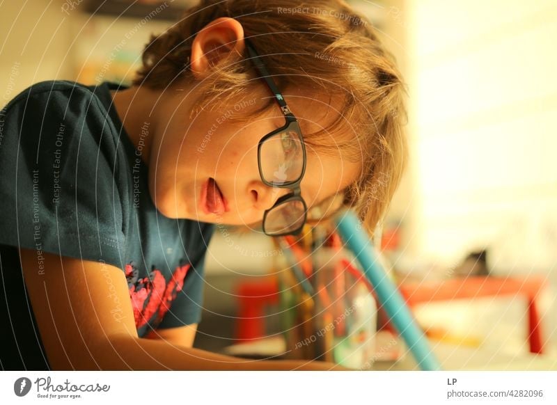 child wearing glasses and writing while being really concentrated Upper body Portrait photograph Pattern Talented Draw Drawing utensils Adventure