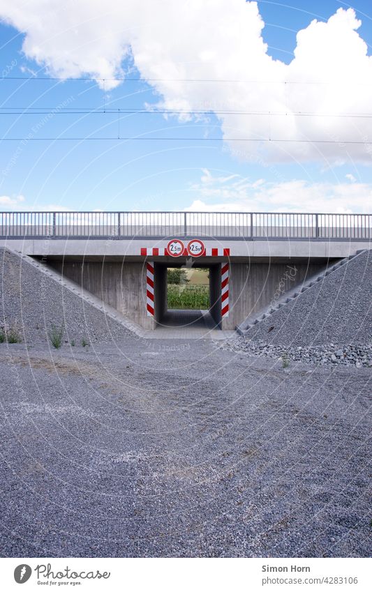 Railway underpass with ballast, sky and cloud Intersection Clouds Stairs Underpass Train travel Gravel path Warning label Tunnel Stretching Sky high voltage