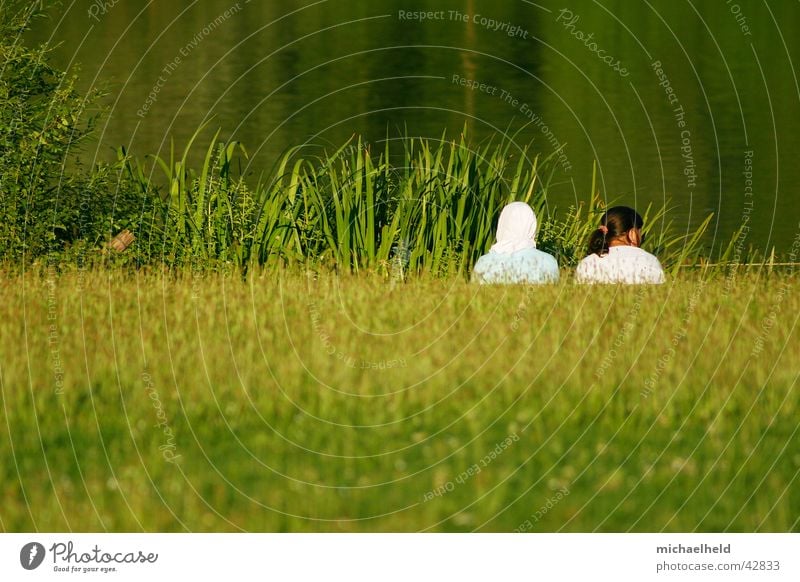 Two alone 2 Girl Woman Meadow Lake Reflection Green Headscarf Islam Ponytail Braids Brown Concealed Calm Loneliness Together Stuttgart Summer Human being Nature