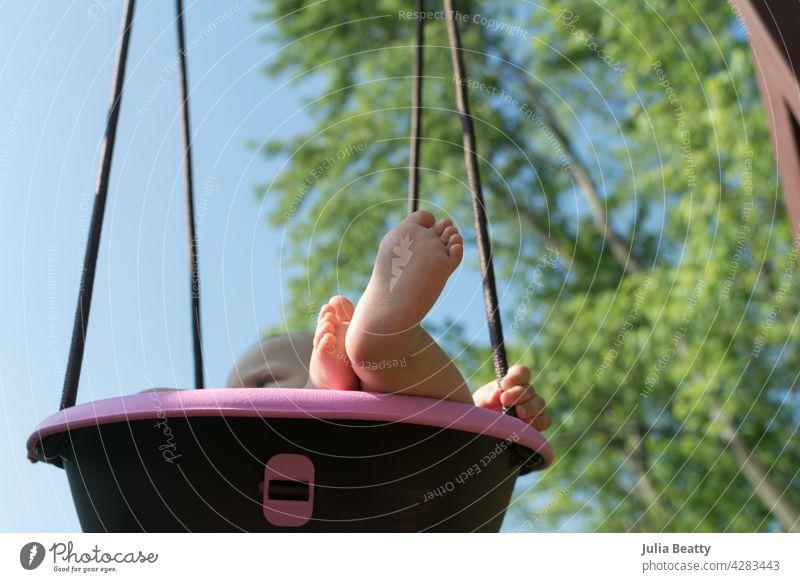 View of baby rocking in pink bucket swing; chubby baby feet and hands visible Swing Bucket swing one year old Toddler Baby Child Toes Feet Plump Swing Set