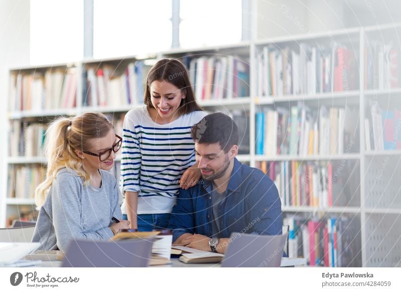 College students in a library enjoying lifestyle young adult people casual caucasian positive happy smiling woman female attractive beautiful bookstore reading