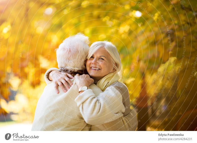 Elderly couple embracing in autumn park family woman love people outdoors portrait together nature two beautiful fall trees yellow senior mature seniors