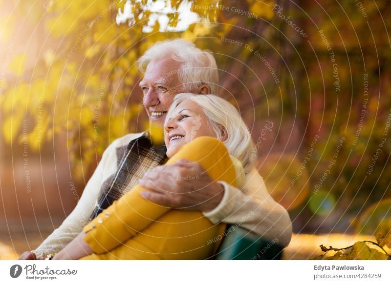 Elderly couple embracing in autumn park family woman love people outdoors portrait together nature two beautiful fall trees yellow senior mature seniors
