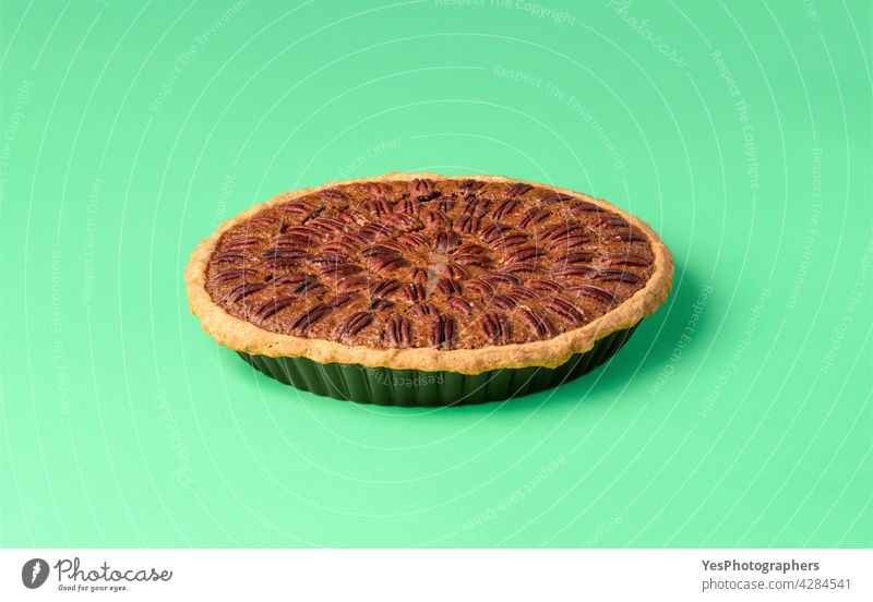 Pecan pie on a green table. Whole pie isolated on a colored background. above american autumn baked bakery brown cake chart christmas copy space corn syrup