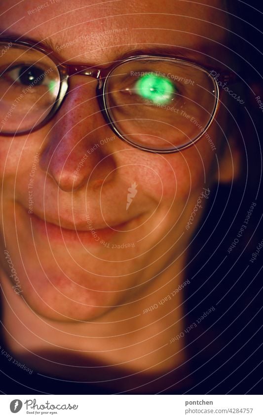 Green reflection in a pair of glasses. Glasses lenses, antireflection coating. Smiling woman with low vision Eyeglasses anti-reflective coating Spectacle lenses