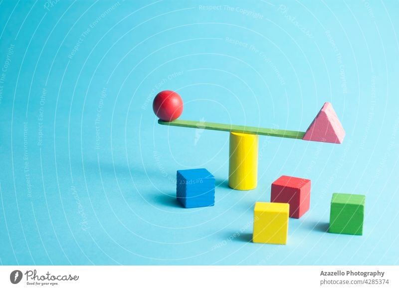 Minimal concept with a stick swingscale and colorful geometric figures balance minimalist composition 3d cube insight flexibility art playground weight outweigh