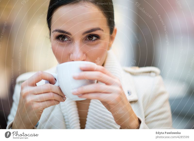 Young woman drinking coffee in cafe beverage enjoying lifestyle young adult people one person casual caucasian positive carefree sitting happy smile smiling