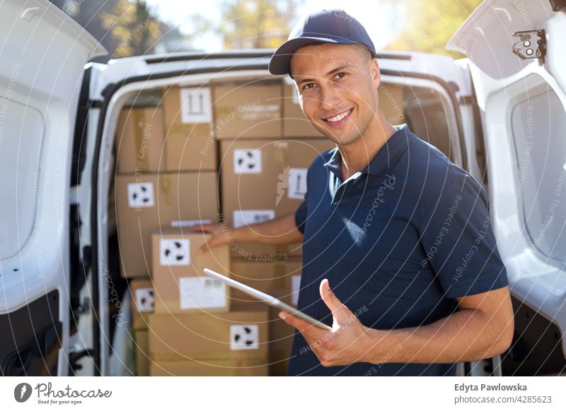 Delivery man with his van delivery van car driver truck people young adult male smiling happy blue collar Courier dispatch rider delivery man delivering package