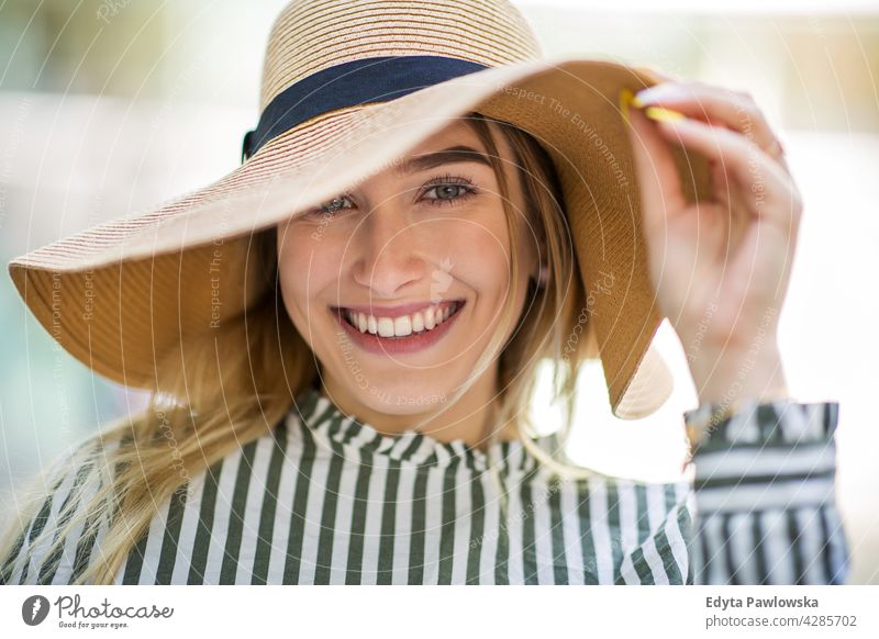 Attractive young woman wearing straw hat holiday vacation fashion park green trees nature freshness enjoying lifestyle adult people casual caucasian positive