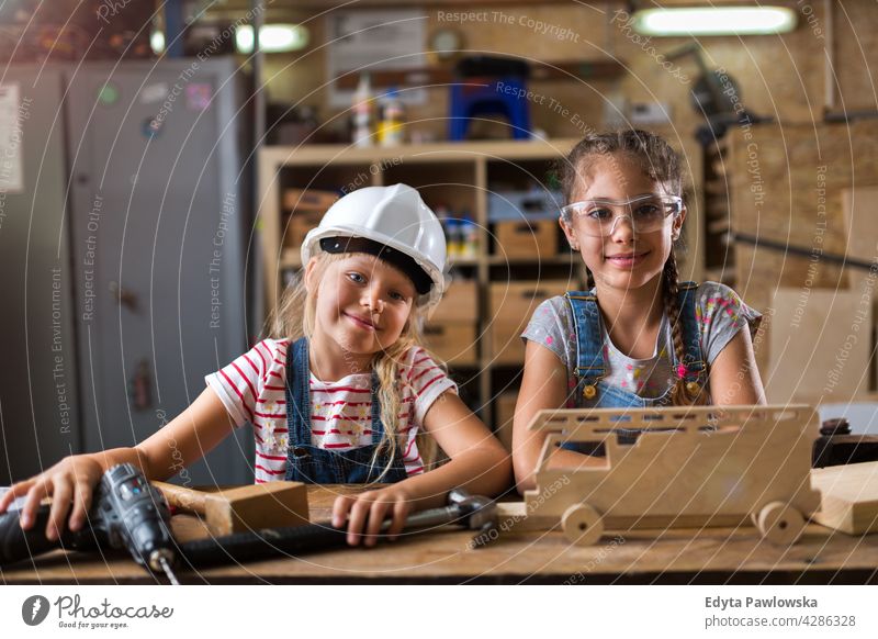 Two young girls doing woodwork in a workshop working people child children kid kids girl power Skill craft Garage Hobby Lifestyle tools Concentration Creativity