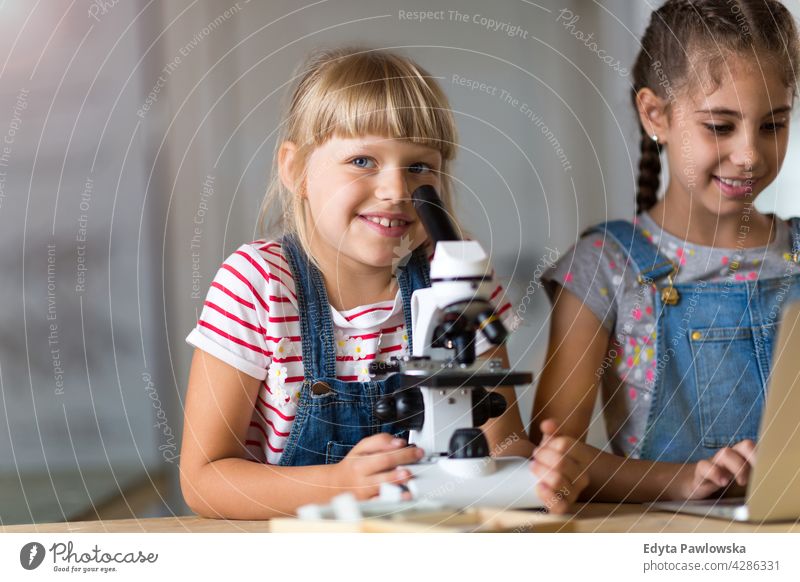 Girls with microscope science workshop learning people child children kid kids girl Skill Lifestyle Concentration Caucasian Childhood desk Education Fun