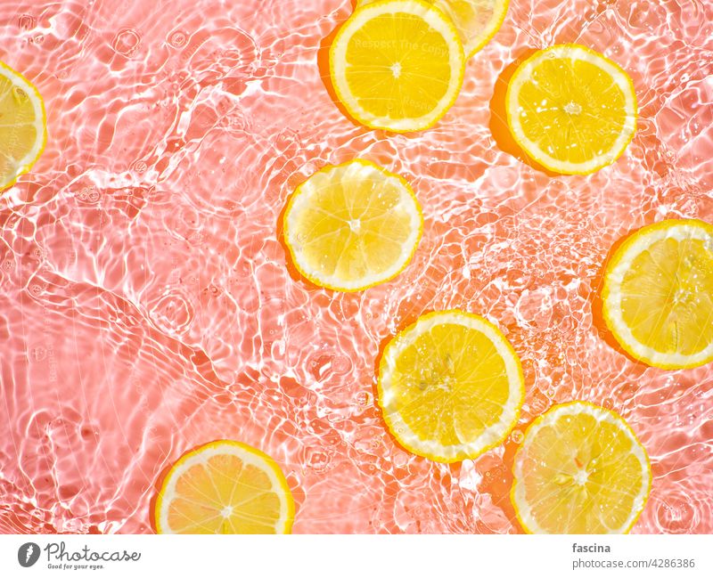 Lemon slices in clean transparent water, pink bg lemon citrus yellow splashing flat lay background copyscape flatlay splashes waves bubbles underwater surface