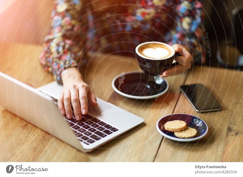 Woman with laptop in cafe breakfast desk espresso morning tea closeup people woman young adult Caucasian one person day coffee shop sitting table office
