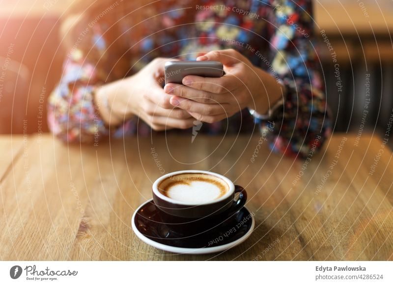 Woman taking photo of coffee with smartphone - close-up cafe hands holding cell mobile cellphone device object restaurant food fun meal overhead overlook