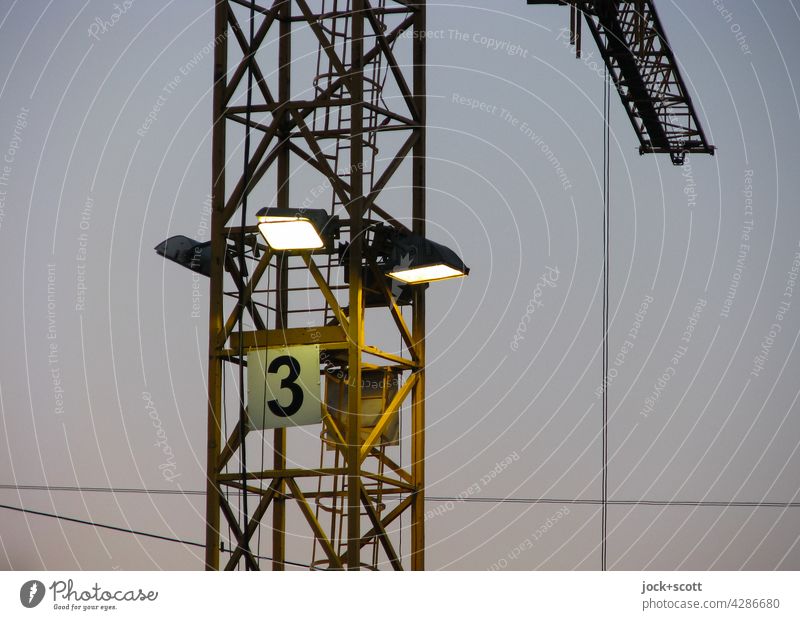 Crane with lighting No. 3 number Digits and numbers Signs and labeling Dusk Lighting Artificial light steel cable Illuminate Workplace Construction crane