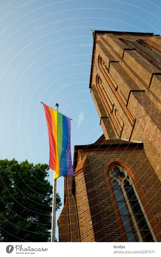 Rainbow flag in front of a Catholic church. Solidarity with believing homosexuals against the Vatican's instruction not to marry homosexuals rainbow flag Church