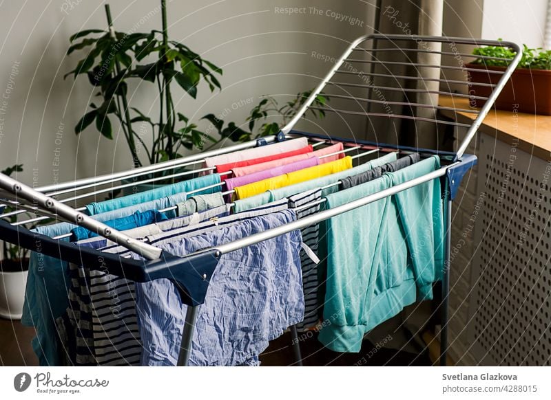 Laundry day Rainbow color clothes hanging on washing line to dry indoors home laundry clean household rainbow clothing housework cotton fresh textile domestic