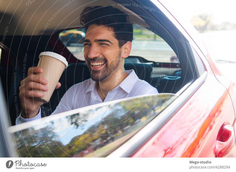 Businessman drinking coffee in car. businessman travel lifestyle taxi professional transportation vehicle backseat closeup to go auto stylish elegant young hot