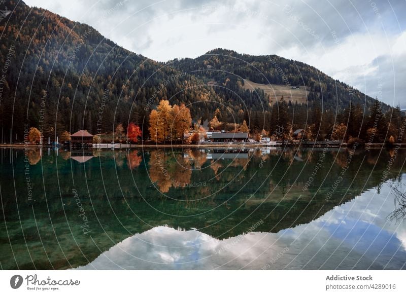 Reflection of mountain and trees on lake in dolomite forest water tourism landscape beautiful village colorful travel nature panorama park dobbiaco trentino