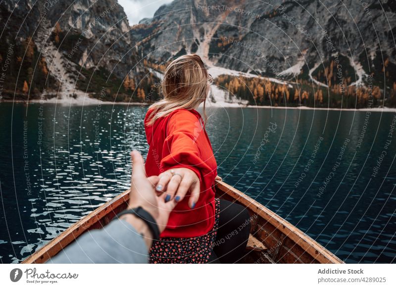Anonymous people on boat in dolomite lake woman forest glacier water romantic tourism mountain landscape cold holding hands beautiful travel nature green park