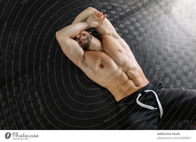 Man lying tired on the floor sport fitness strong athletic male working out bodybuilding training gym exhausted lying down muscular healthy athlete man exercise