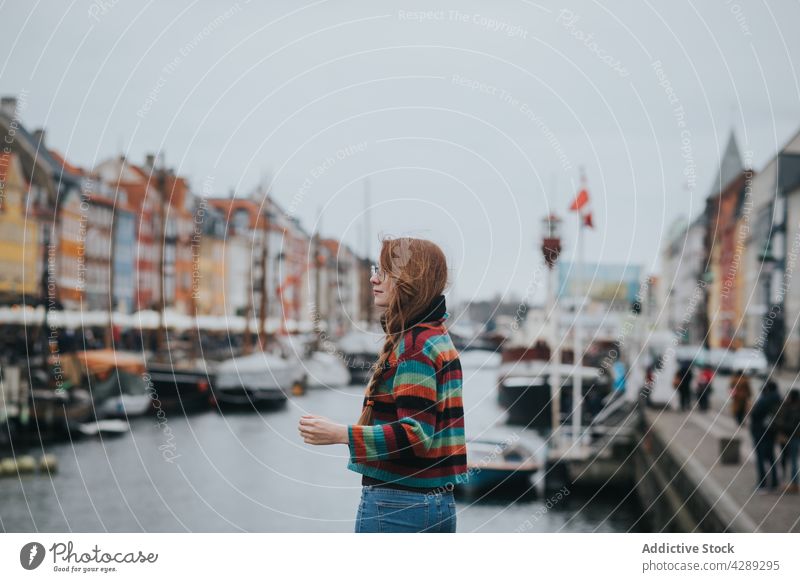 Woman standing on pier of canal woman shore marina moor boat city district embankment female water harbor transport yacht town europe bay coast red hair