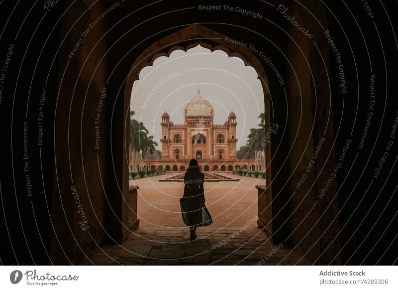 Woman standing in arched passage against Safdarjung Mausoleum woman silhouette admire palace tomb tourism destination sightseeing landmark heritage female