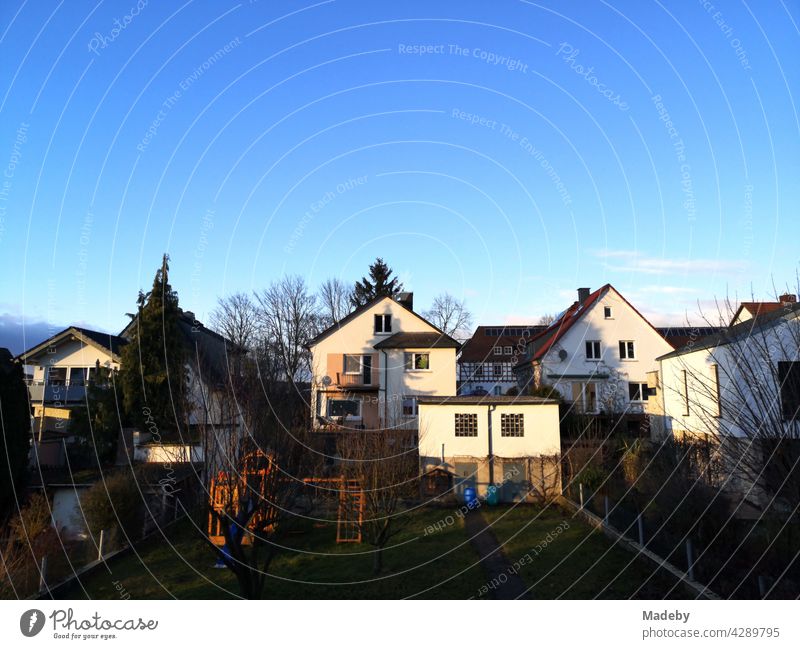 Typical houses with pointed gable as a home in the light of the setting sun in front of a bright blue sky in the Hessian province in Wettenberg Krofdorf-Gleiberg near Giessen in Central Hesse