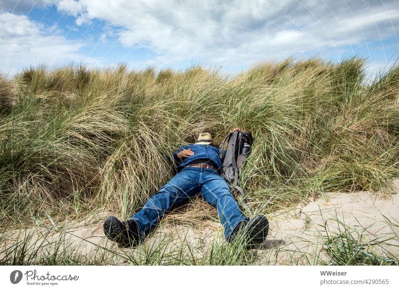 Stranded: An overworked city man has reached the beach by the last of his strength duene Beach dune Sleep rest vacation Lie relax workoholic reengineered tired