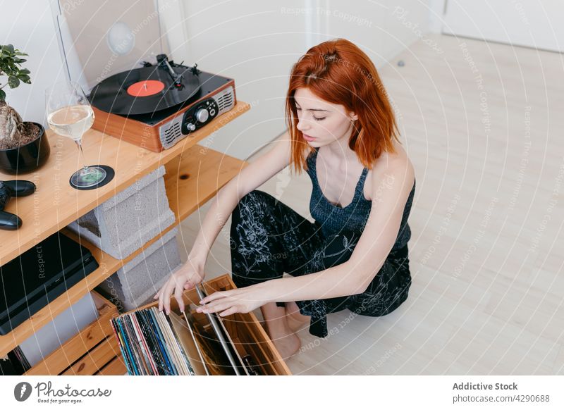 Woman choosing vinyl record from box at home woman choose music nostalgia art classic vintage house select wooden material choice player retro device spare time
