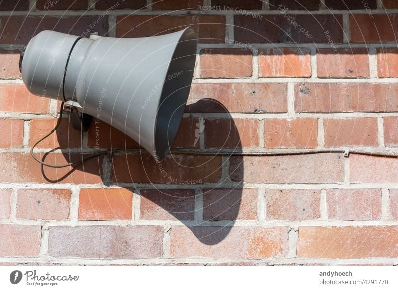 Megaphone in front of an old brick wall advertisement advertising alarm alert announce announcement attention Background beware broadcasting careful caution