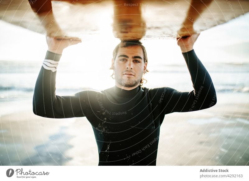 Surfer at the beach carrying surfboard man nature sunset wave outdoors portrait wetsuit seacoast male sportsman surfing hobby surfer ocean seaside calm horizon