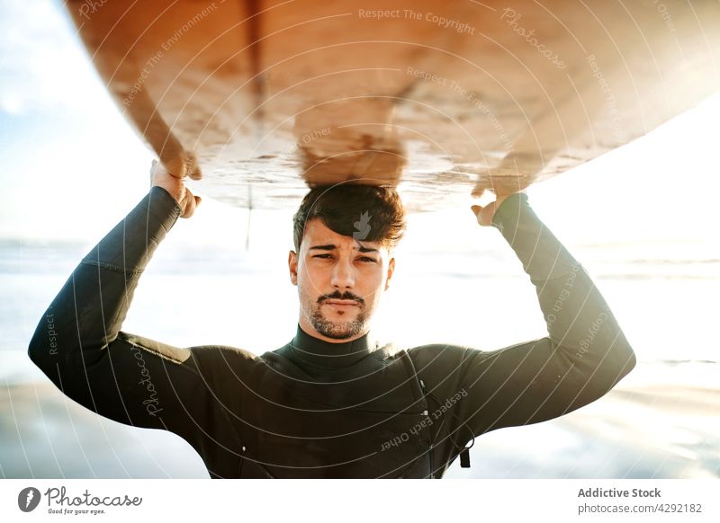Surfer at the beach carrying surfboard man nature sunset wave outdoors portrait wetsuit seacoast male sportsman surfing hobby surfer ocean seaside calm horizon