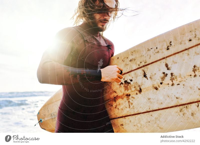Surfer at the beach with surfboard man nature sunset wave outdoors run wetsuit seacoast male sportsman surfing hobby surfer ocean seaside calm excited water