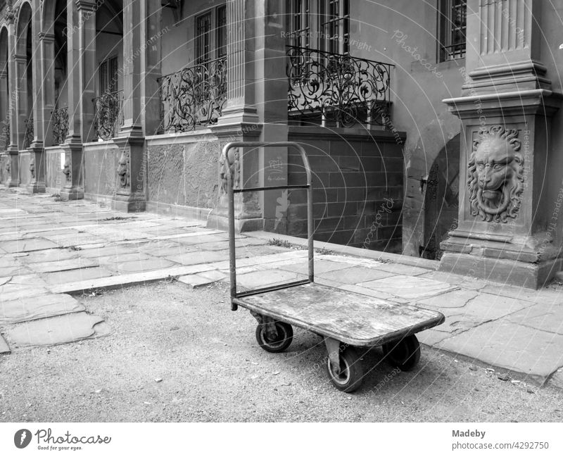 Old platform car in the courtyard of the Isenburg Castle with old renaissance facade in Offenbach on the Main in Hesse, photographed in neo-realistic black and white