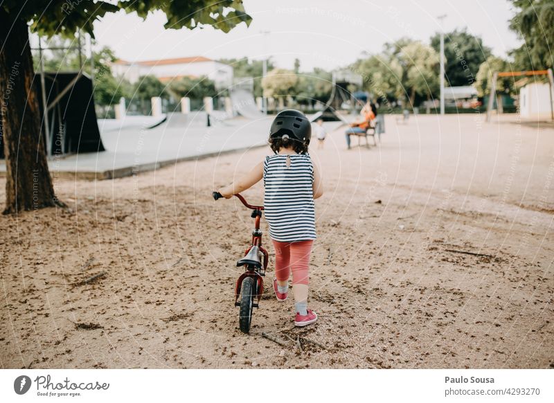 Rear view girl with bike Child 1 - 3 years Girl Park Authentic Human being Colour photo Toddler Exterior shot Infancy Day Happy Lifestyle Happiness