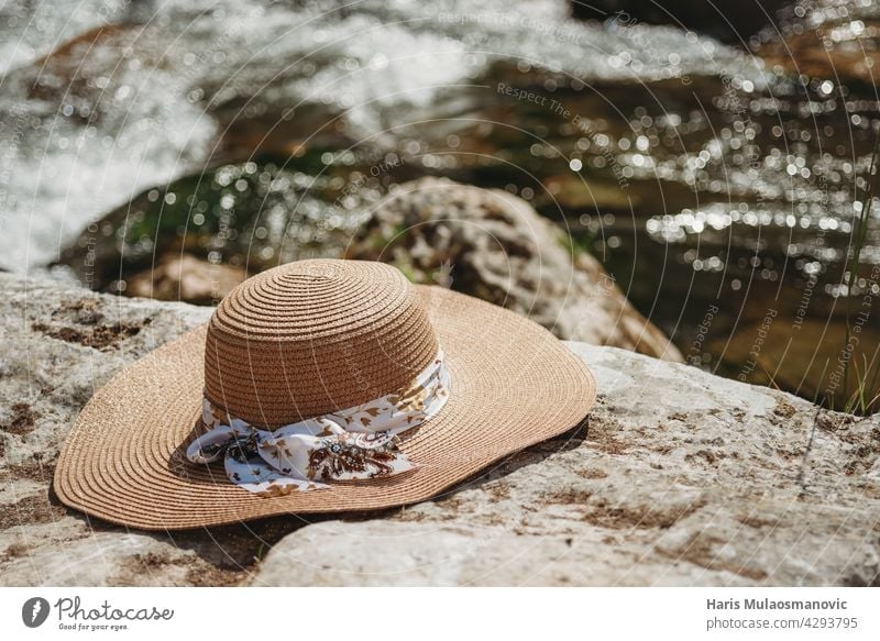 Summer hat on the rocks by the river accessory background beach blue close-up coast concepts couture directly elegance enjoy fashion frame holiday image life