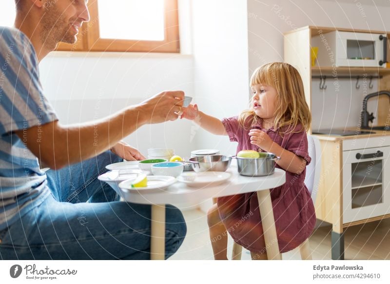 Father and daughter having a tea party at home house man dad father family parent relatives child girl little girl kid kids children relationship together