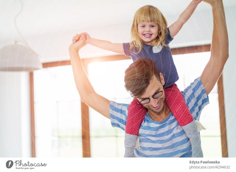Father Giving Daughter Piggyback Ride home house man dad father family parent relatives child daughter girl little girl kid kids children relationship together