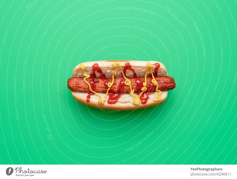 Hot dog top view minimalist on a green background. above american bread bun calories color copy space cuisine cut out delicious eat fast fastfood flat lay fresh