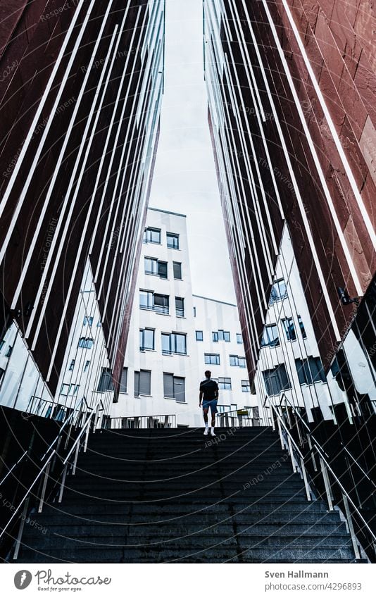 Man walking down a staircase between two imposing buildings Architecture Building Modern architecture Facade Esthetic Symmetry Design Abstract Arrangement Line