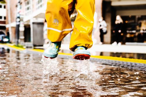Child jumps happily into a puddle Puddle Water reflection Asphalt Street Wet Reflection Jump Rain Ground Bad weather Weather Clouds Playing feet Freedom Infancy