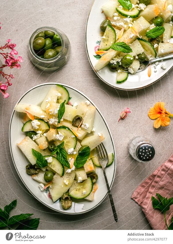 Melon salad with cucumbers and olives healthy food diet vegan serve table melon herb napkin salt shaker plate organic appetizer delicious dish portion nutrition