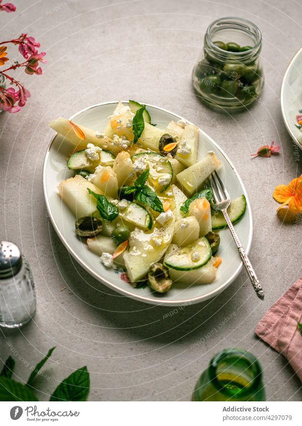 Melon salad with cucumbers and olives healthy food diet vegan serve table melon herb napkin salt shaker plate organic appetizer delicious dish portion nutrition