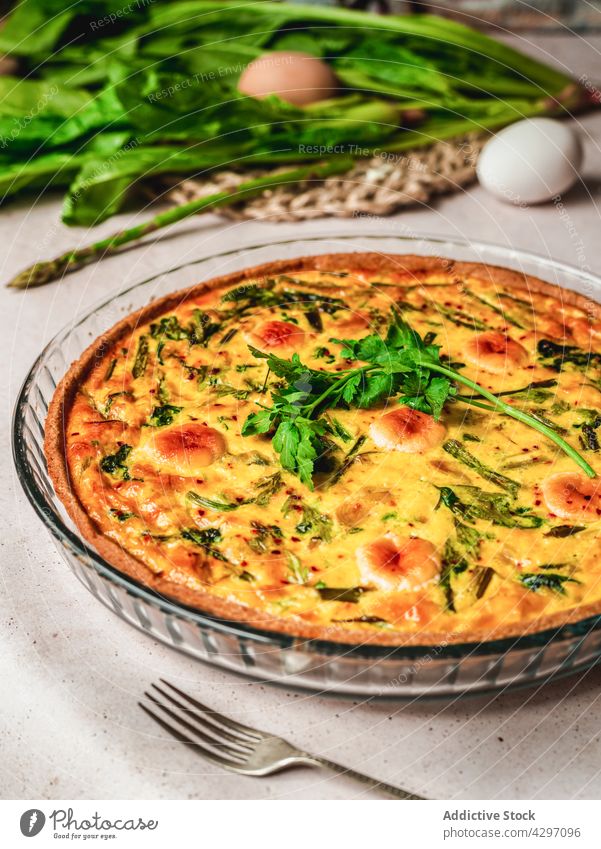 Delicious quiche placed near ingredients tart dish food spinach asparagus egg parsley fresh nutrition cuisine vegetable french tradition authentic organic herb