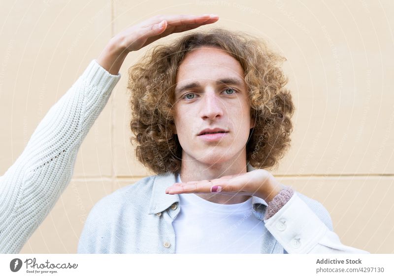 Young curly man demonstrated with crop girlfriends curly hair portrait human face peaceful frame style natural serious serene emotionless unemotional masculine